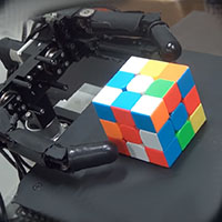 Робот с тремя пальцами собирает кубик Рубика