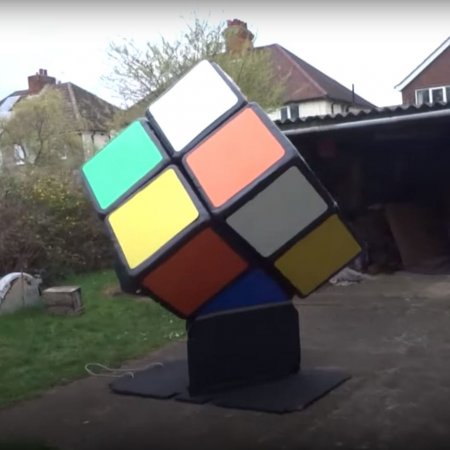 картинка - огромный кубик Рубика 2 на 2 во дворе дома