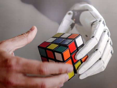 картинка - бионический протез помогает собрать кубик Рубика